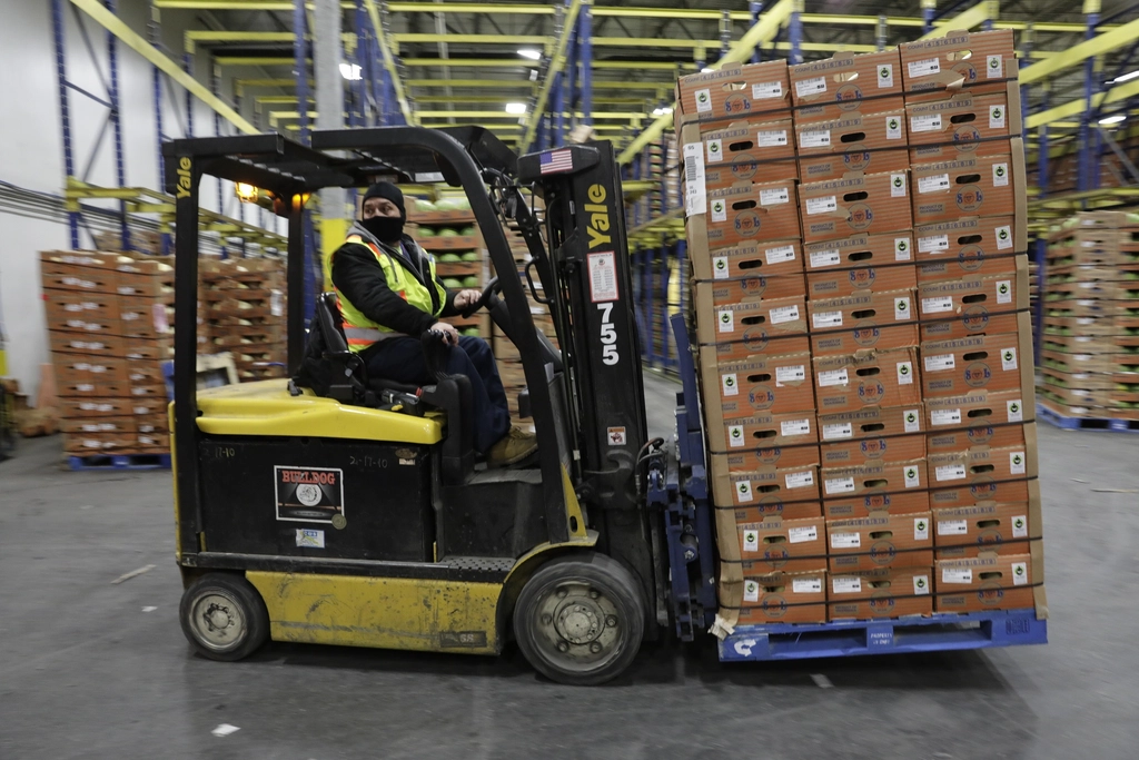 Forklift moving a pallet of boxed products in a warehouse